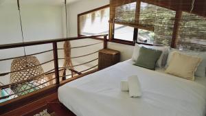 a bedroom with a white bed and a window at Villa Isleñas - Solar, Starlink, Pool in General Luna