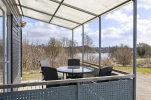 a screened in porch with a table and chairs at Sorø Camping & Cottages in Sorø