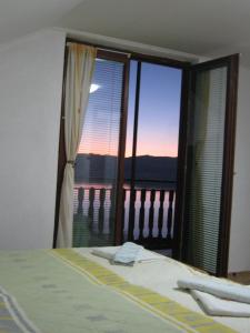 een slaapkamer met een bed en een raam met uitzicht bij Risto's Guest House in Ohrid