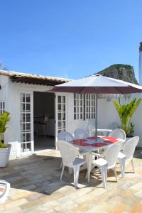 a patio with a table and chairs and an umbrella at Roxy Apartments in Rio de Janeiro