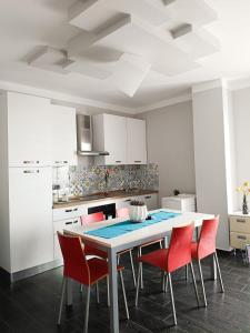 a kitchen with a table and red chairs at Playadeivo in Pineto +10 photos