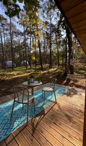 a patio with a table and two chairs on a deck at Planeta Glamping in Zalesie Górne
