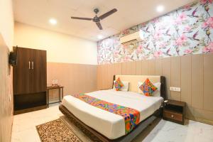 a bedroom with a bed and a wall with flowers at Via The Arrow in New Delhi
