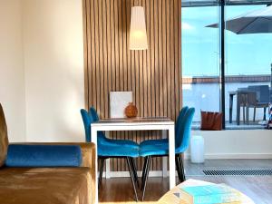 a dining room with a table and blue chairs at Angel MINT Apartment - FREE PARKING - Balcony in Krakow