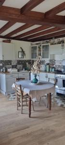 a kitchen with a table with a vase of flowers on it at Maison dans le Beaujolais vert in Thizy-les-Bourgs