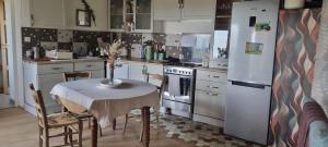 a kitchen with a table and a refrigerator at Maison dans le Beaujolais vert in Thizy-les-Bourgs +10 photos