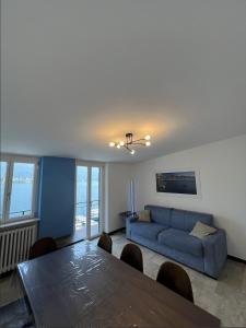 a living room with a blue couch and a table at COZY LAKE COMO APARTMENTS in Valmadrera
