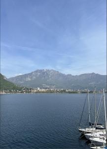 two sailboats on a lake with mountains in the background at COZY LAKE COMO APARTMENTS in Valmadrera