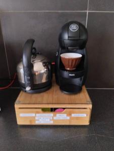 a coffee maker sitting on top of a box at La Grande Grange 89 in Saint-Martin-des-Champs