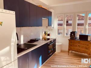 a kitchen with blue cabinets and a white refrigerator at Fuentes 8 in Soria +13 photos