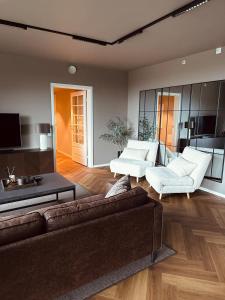 a living room with a couch and two white chairs at Bergen Apartment with a view in Bergen