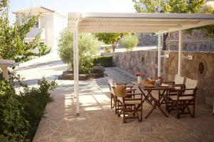 a patio with a table and chairs under a pavilion at Birds Bay Resort in Petra