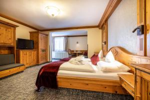 a bedroom with a large bed and a television at Hotel Alpenrose in Zauchensee +31 photos