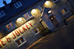 a lit up sign on the side of a brick building at The Horse & Jockey in Alfreton