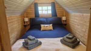 a small room with a bed with two ottomans at Oak Hill Escape in Welshpool
