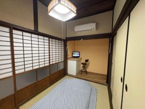 a room with a bed and a desk and a chair at 指宿古民家宿 in Ibusuki