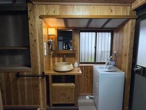 a bathroom with a sink and a washing machine at 指宿古民家宿 in Ibusuki