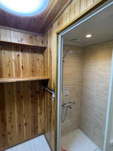 a bathroom with a shower with wood paneling at 指宿古民家宿 in Ibusuki +14 photos