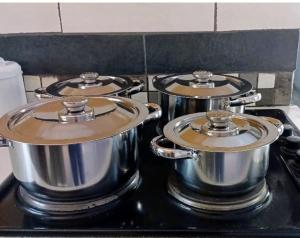 three pots sitting on top of a stove at DeltaGateway selfcatering in Maun Airport