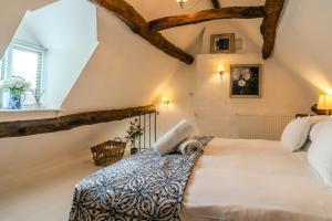 a bedroom with a large bed in the attic at 4 Crown Cottages in Moreton in Marsh