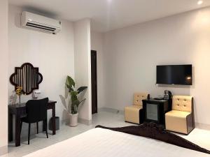 a bedroom with a bed and a desk and a tv at Glory Hotel in Can Tho