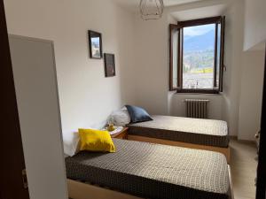 two beds in a room with a window at Incanto dei sibillini- Piazza Perfetti 16 in Sarnano