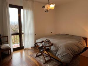 a bedroom with a bed and a large window at Tintin in Montagne in Postalesio