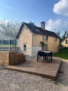 a wooden deck with a table in front of a house at Gîte des sabotiers in Le Boissenet