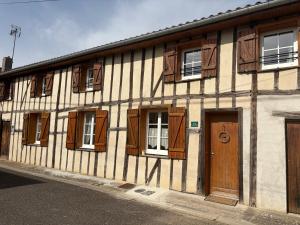 a building with wooden doors and windows on a street at Le Bois Flotté in Arrigny
