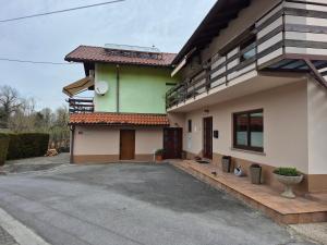 a green and white house with a driveway at Apartmaji Karbic in Postojna