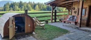 a gazebo with a chair and a bench next to a house at western cottage in Rečica ob Savinji