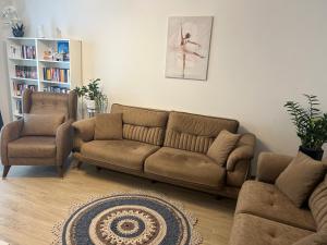 a living room with a couch and two chairs at Bella in Târgu-Mureş