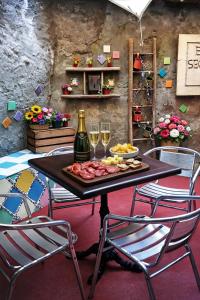 a table with a plate of food and two glasses of wine at Il Cortiletto in Susa