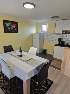 a room with a table and chairs and a kitchen at Apartman Jelena in Surčin
