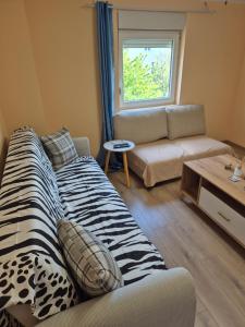 a living room with a zebra print couch and a table at Apartman Jelena in Surčin