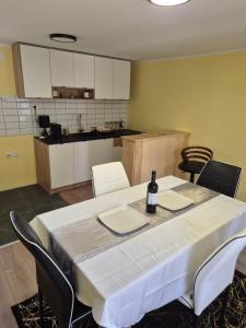 a table with a bottle of wine sitting on top of it at Apartman Jelena in Surčin +17 photos