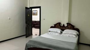 a bedroom with a bed with a wooden head board at Hotel SIDAPORE in Lamobuang