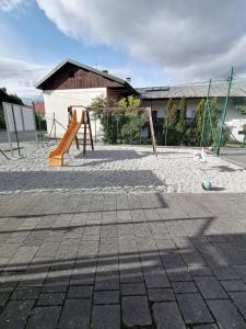 a playground with a slide and a swing set at Apartmaji Karbic in Postojna