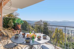a table and chairs on a balcony with a view at Clara YourHostHelper in Montauroux