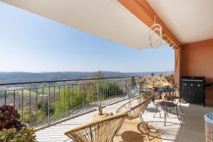 a balcony with chairs and a table and a view at Clara YourHostHelper in Montauroux