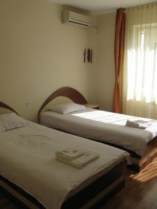 two beds sitting next to each other in a bedroom at Hotel Nakra in Radnevo