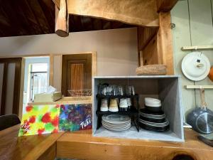 a kitchen with a shelf with plates on it at Retreat 舞月 in Tanabe +17 photos