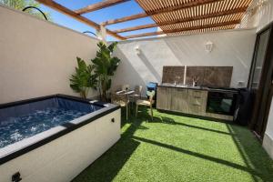a backyard with a hot tub and a kitchen at Bella Gallery Terrasini in Terrasini