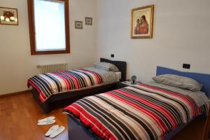 sypialnia z dwoma łóżkami i oknem w obiekcie Agriturismo Memento w mieście Follina