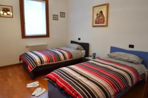 1 dormitorio con 2 camas y ventana en Agriturismo Memento, en Follina