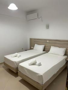 two beds sitting next to each other in a room at Kloen Sunset Villa in Sarandë