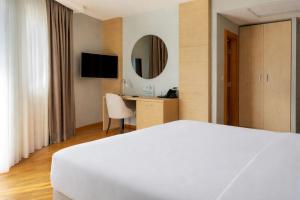 a hotel room with a white bed and a desk at Hotel Jana in Međugorje