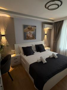 a bedroom with a large bed with two towels on it at Abla's sweet home in Tirana