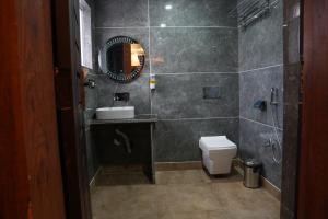 a bathroom with a sink and a toilet and a mirror at Green Inn in Pahalgām