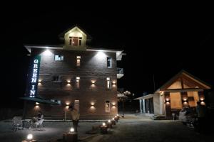a man standing in front of a building at night at Green Inn in Pahalgām